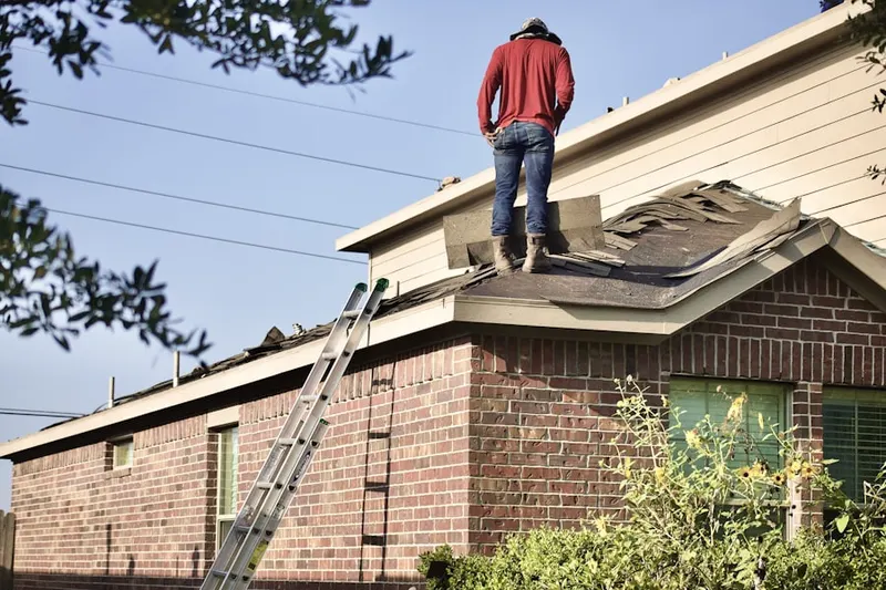 Professional roofer working on a residential roof in Gandy